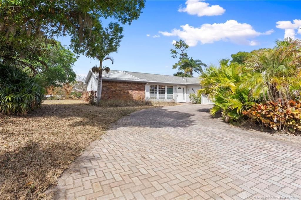2493 Southwest Murphy Road Palm City, FL 34990 - Photo 4 of 50 a front view of a house with a yard and a garden