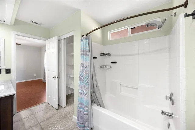 a view of a room with wooden floor a ceiling fan and a window
