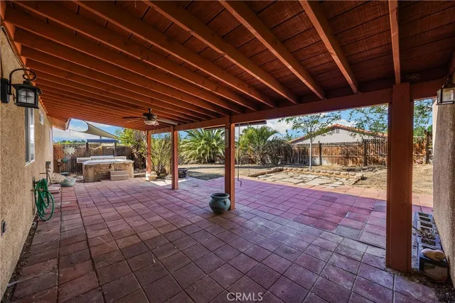 an empty room with wooden floor and a ceiling fan