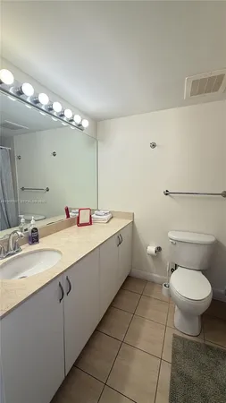 a spacious bathroom with a granite countertop sink a toilet and a mirror