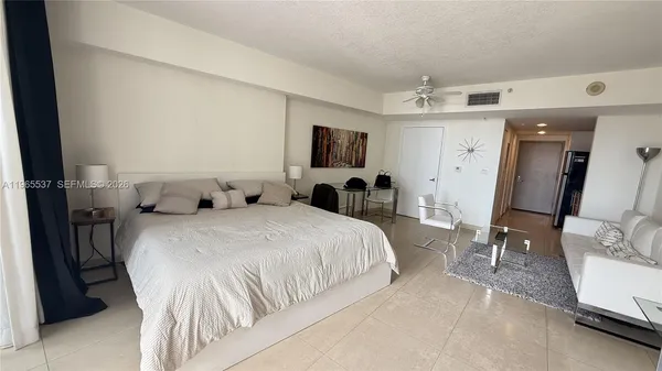 a spacious bedroom with a bed and a flat screen tv