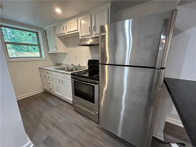 a kitchen with stainless steel appliances a refrigerator sink and cabinets