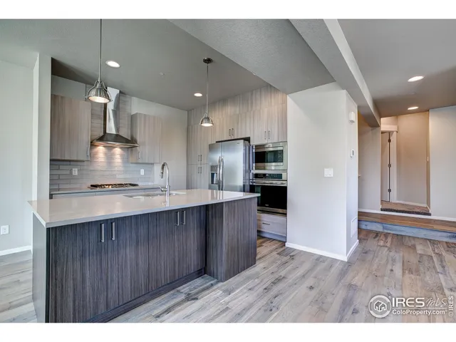 a open kitchen with kitchen island a sink stainless steel appliances and cabinets