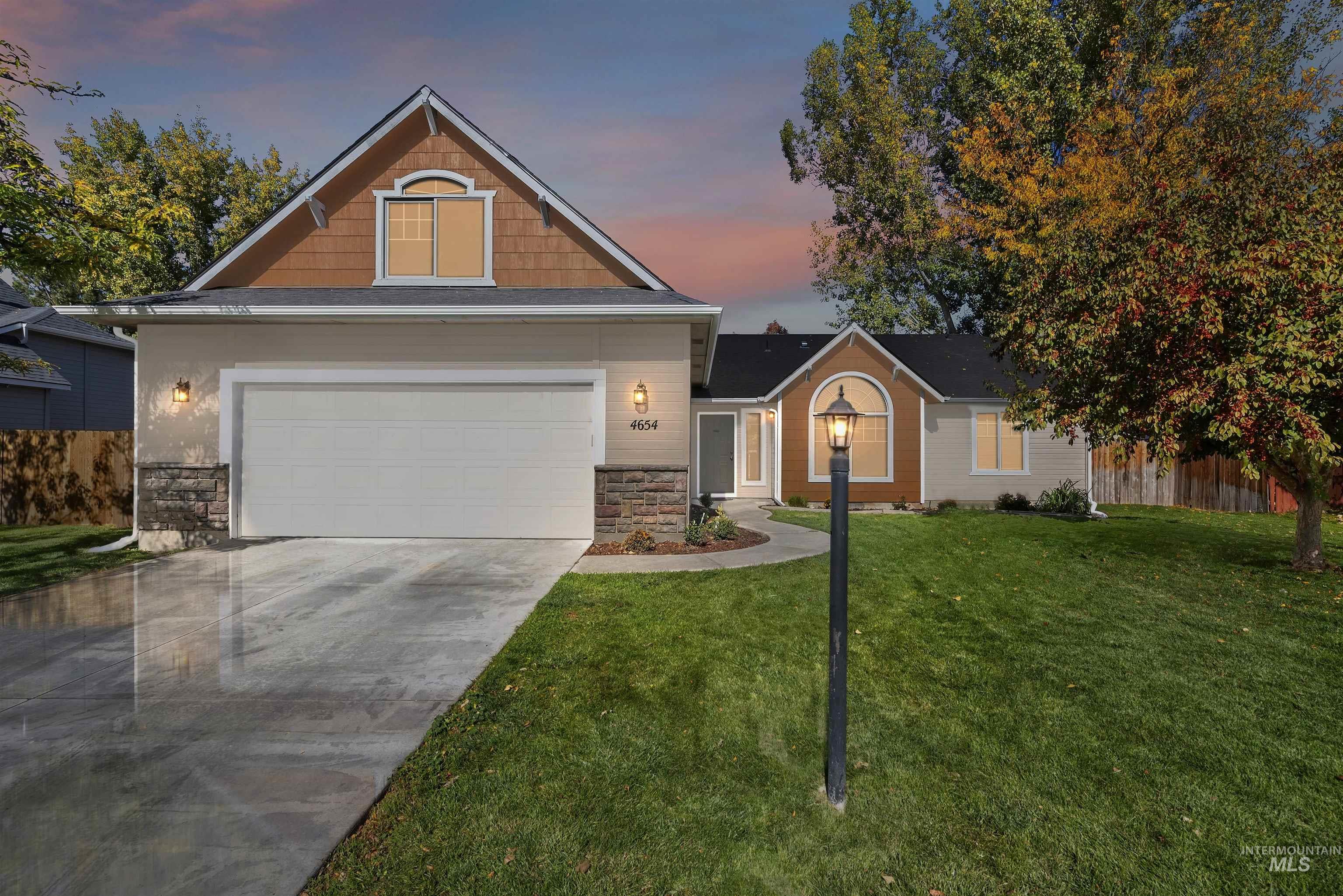 Craftsman house with stone siding, a yard, concrete driveway, and a garage