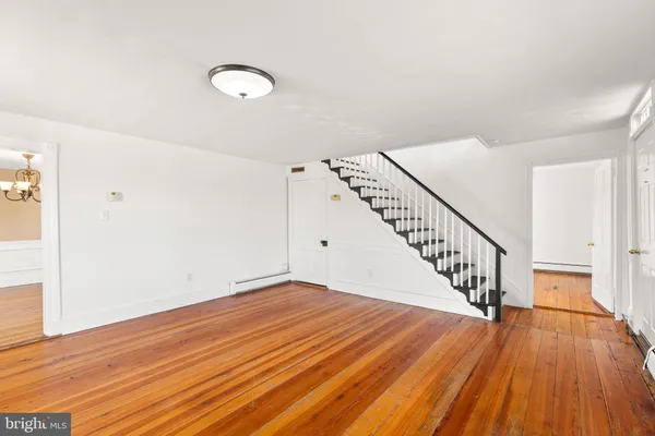 a view of a room with wooden floor and white walls
