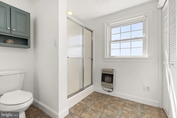 a bathroom with a toilet and a shower