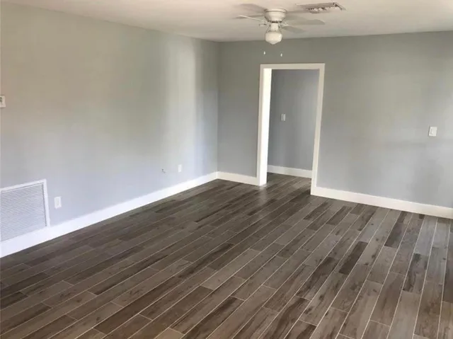 a view of an empty room with wooden floor