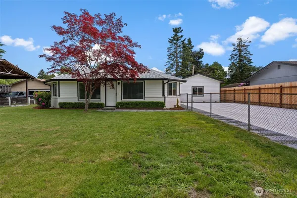 a view of a house with a yard and sitting area