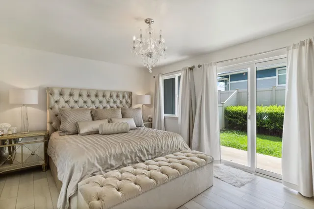 a bedroom with a large bed and a chandelier