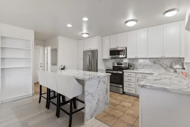 a kitchen with kitchen island a refrigerator stove microwave and cabinets