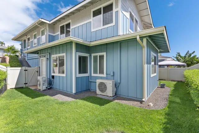 a living room with furniture kitchen view and a wooden floor