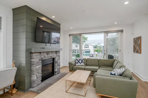 a living room with furniture a flat screen tv and a fireplace