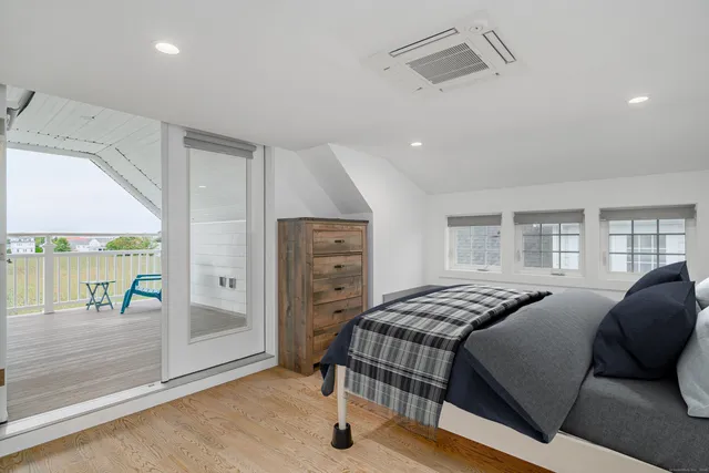 a bedroom with a bed and large windows