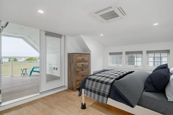 a bedroom with a bed and large windows