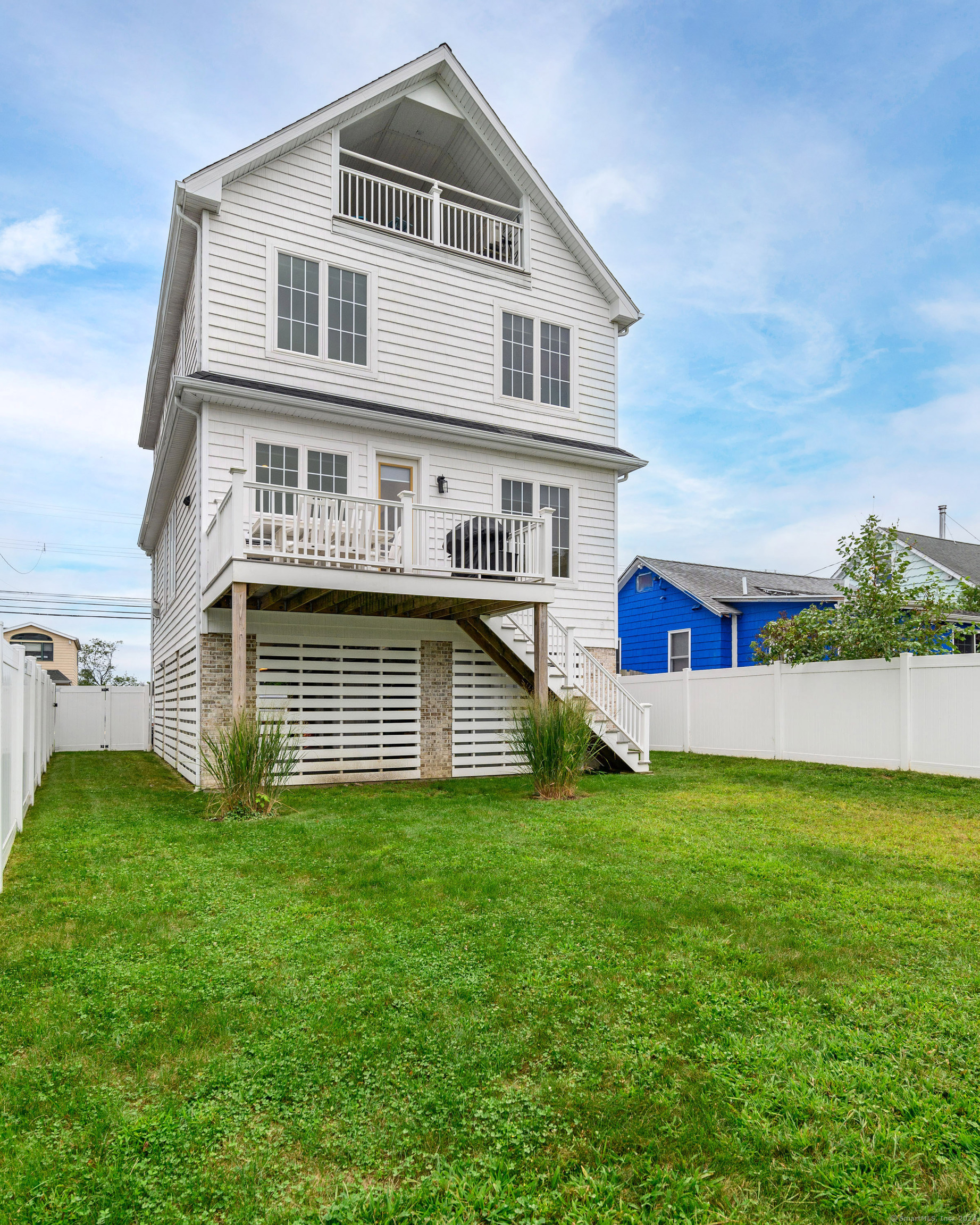 1033 Reef Road Fairfield, CT 06824 - Photo 30 of 32 a front view of a house with a yard and garage