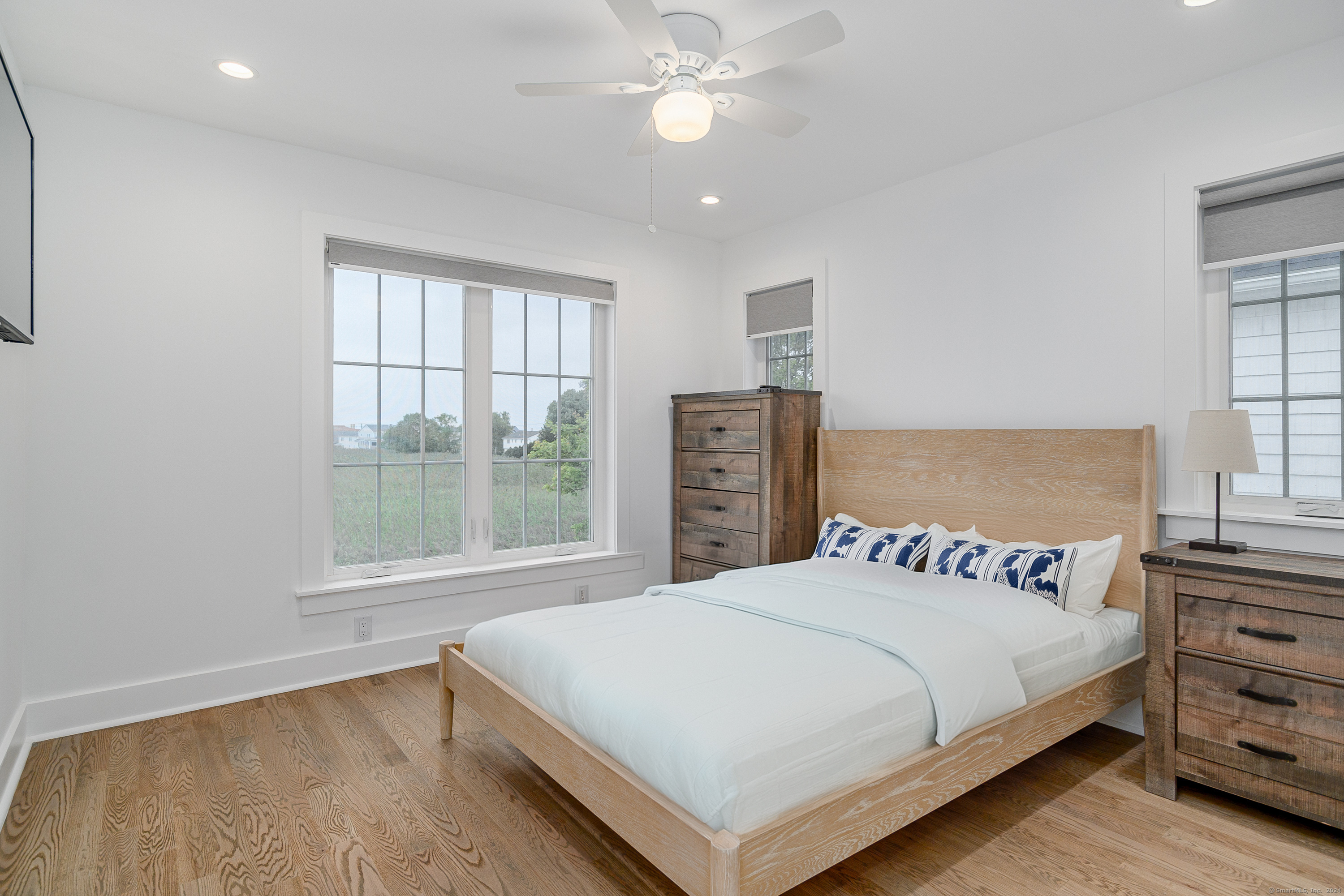 1033 Reef Road Fairfield, CT 06824 - Photo 4 of 32 a bedroom with a large bed and a chandelier