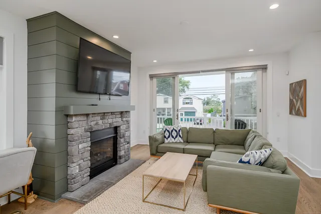 a living room with furniture a flat screen tv and a fireplace