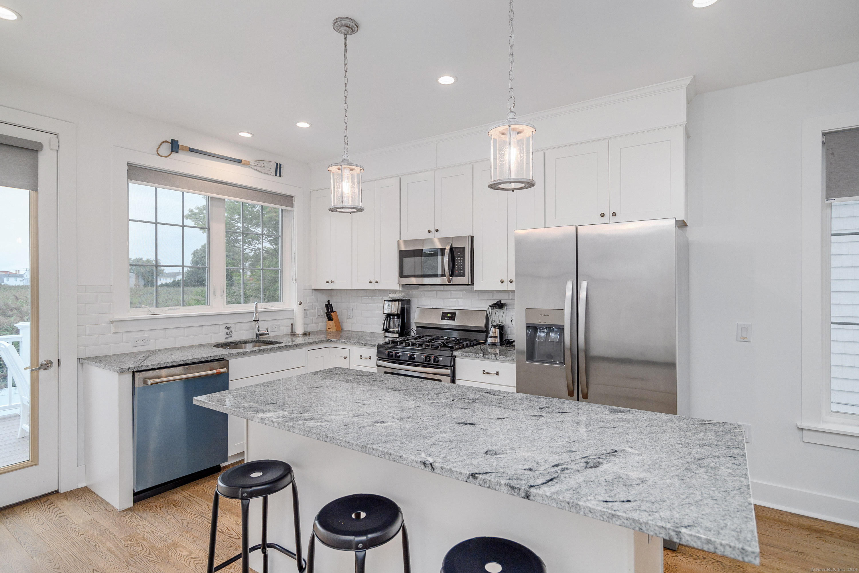 1033 Reef Road Fairfield, CT 06824 - Photo 8 of 32 a kitchen with refrigerator a sink and chairs