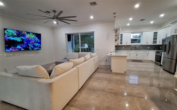 a large kitchen with a sink stainless steel appliances and cabinets
