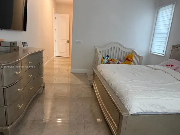 a bedroom with a bed and a flat tv screen on the dresser
