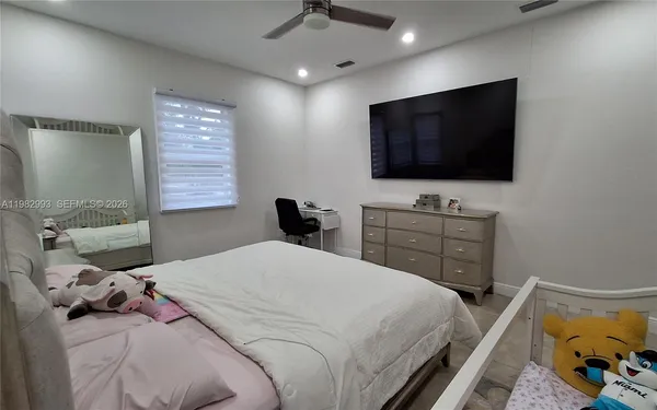 a bedroom with a bed and a flat screen tv