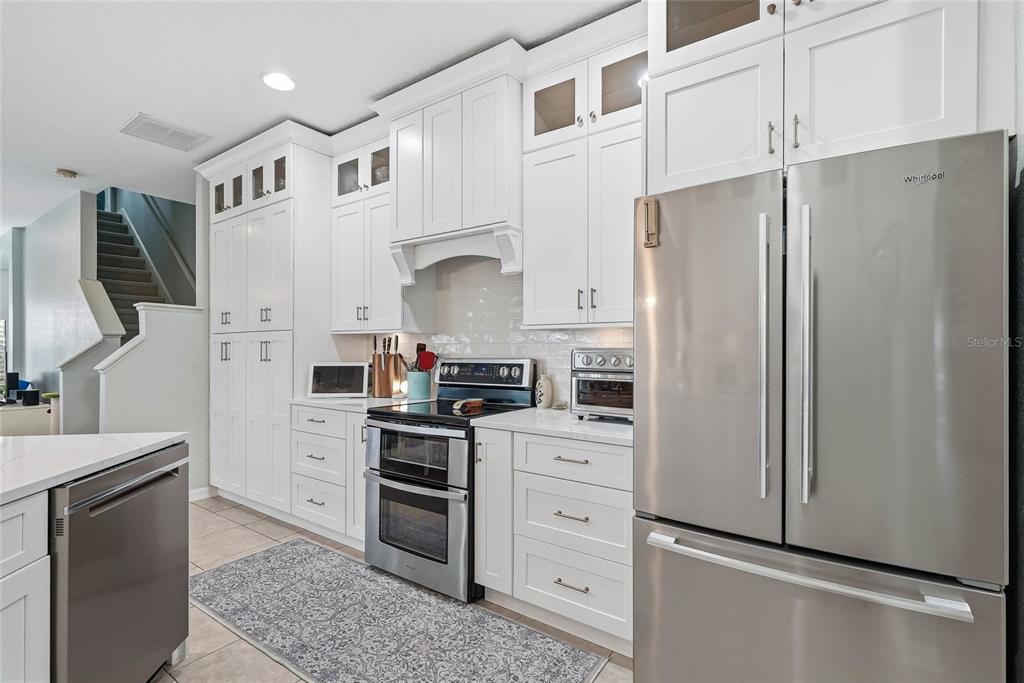 16748 Midsummer Lane Spring Hill, FL 34610 - Photo 16 of 52 a kitchen with stainless steel appliances a refrigerator stove and white cabinets