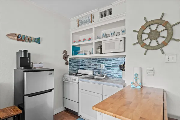 a kitchen with a stove a refrigerator and cabinets