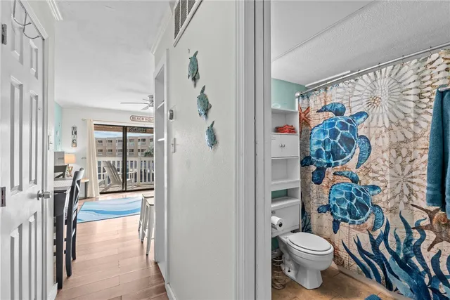 a bathroom with a toilet sink and shower curtain