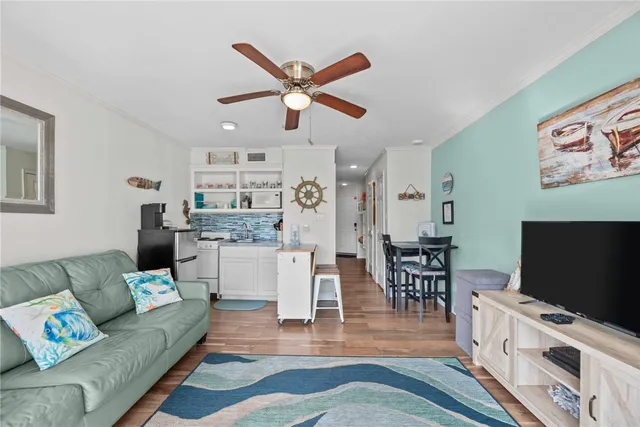 a living room with furniture and a flat screen tv with wooden floor