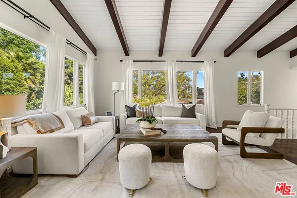 a living room with furniture and large windows