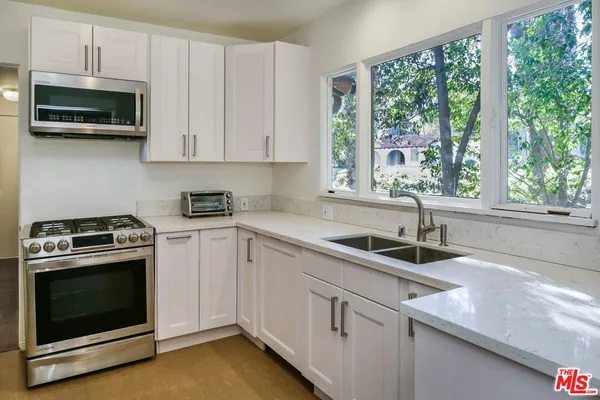 a kitchen with stainless steel appliances a refrigerator a stove and a sink