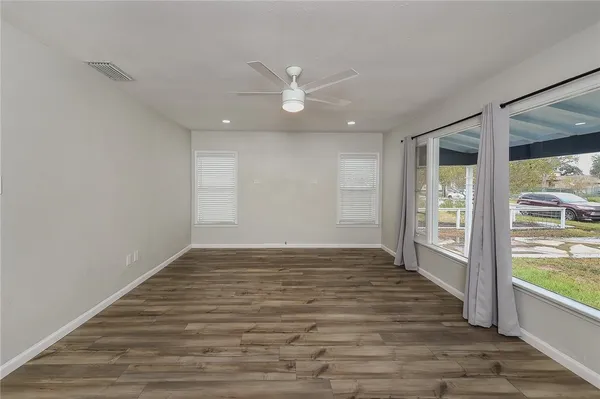 an empty room with window and wooden floor