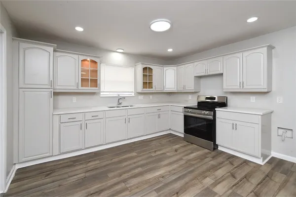 a kitchen with granite countertop a sink and a stove