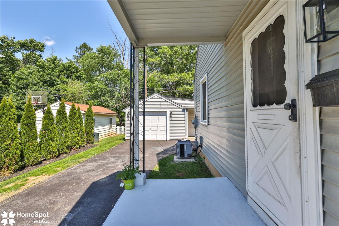 415 Willow Road Hellertown, PA 18055 - Photo 9 of 25 A well-maintained side yard and driveway lead to a detached garage and covered entryway.