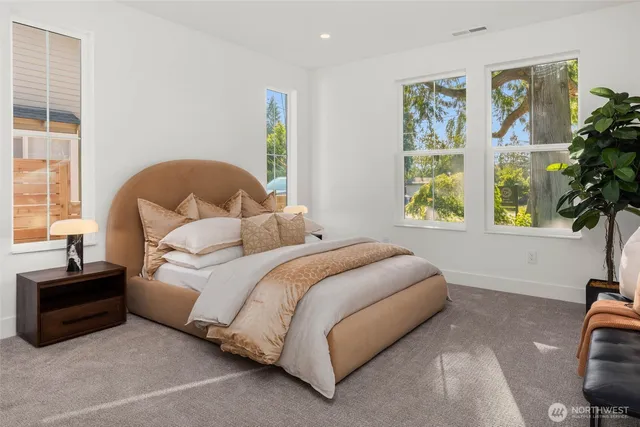 a bedroom with a bed and a large window
