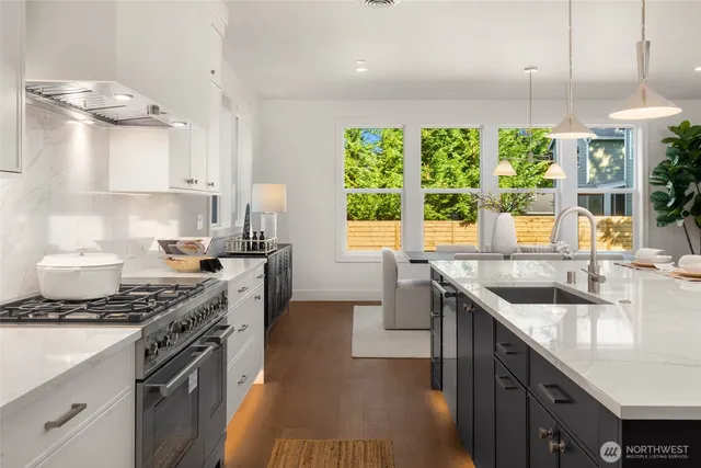 a kitchen with stainless steel appliances granite countertop a sink stove and cabinets