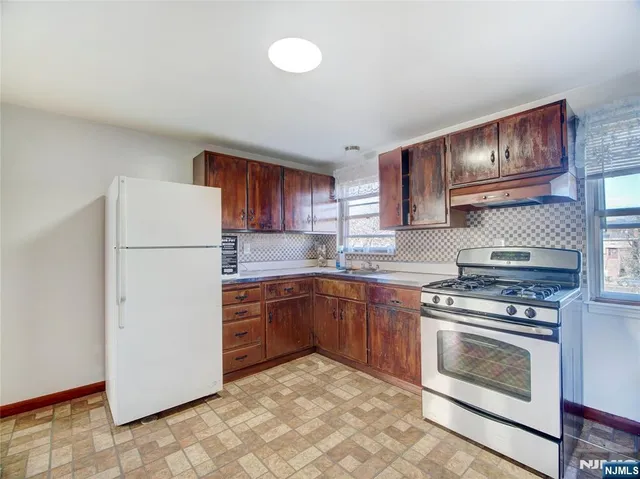 a kitchen with cabinets stainless steel appliances and a counter space