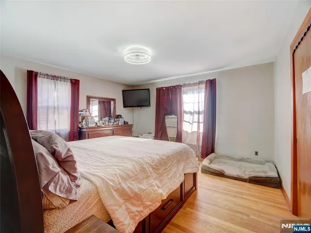 a spacious bedroom with a bed and wooden floor