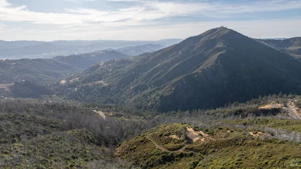 a view of a mountain range with lush green forest