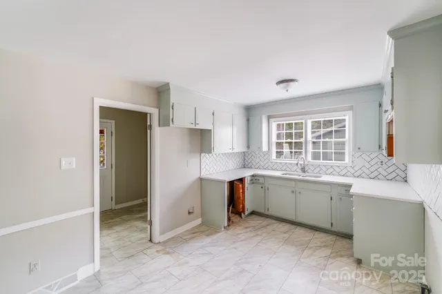 a kitchen with stainless steel appliances granite countertop a sink and a refrigerator
