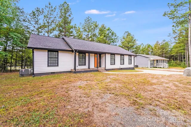 a view of a house with backyard and deck