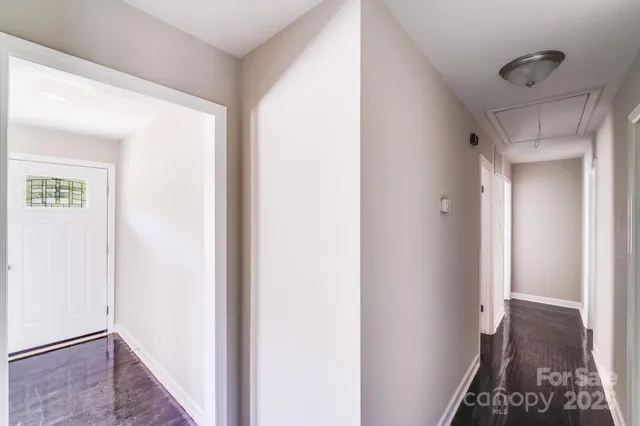 a view of hallway with closet and wooden floor