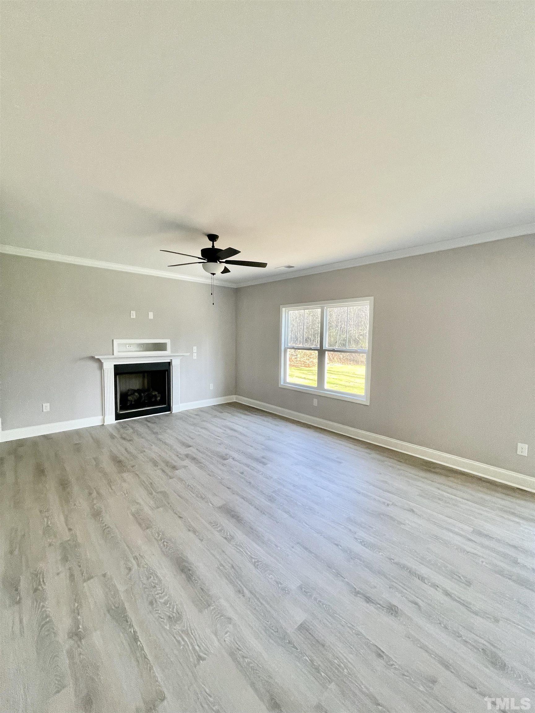 10667 West Old Spring Hope Road Spring Hope, NC 27882 - Photo 7 of 9 an empty room with wooden floor chandelier and windows