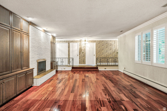 1365 Sumac Drive Logan, UT 84321 - Photo 13 of 66 Expansive room featuring rich wood-finish flooring, a white brick fireplace with a hearth, and substantial built-in cabinetry