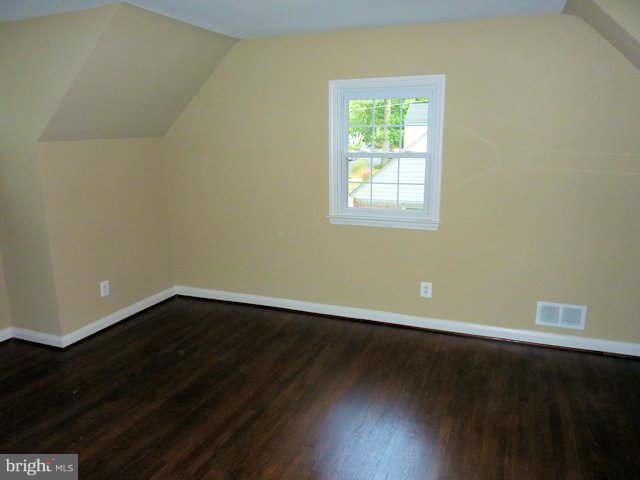 6521 Banbury Road Baltimore, MD 21239 - Photo 13 of 29 a view of an empty room with wooden floor and a window