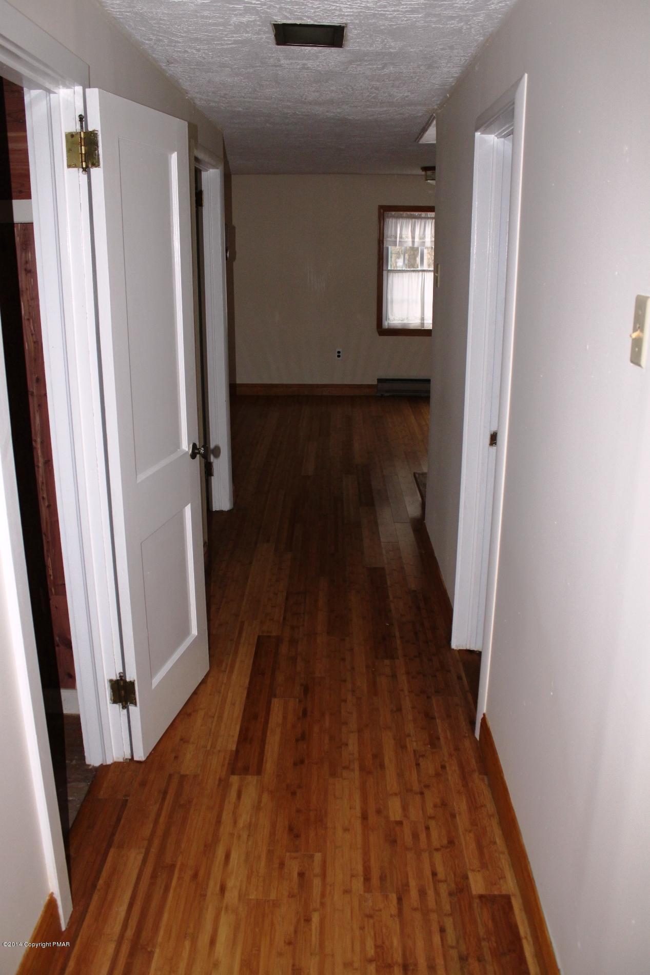 1055 Bush Road Cresco, PA 18326 - Photo 11 of 24 a view of a hallway with wooden floor and stairs