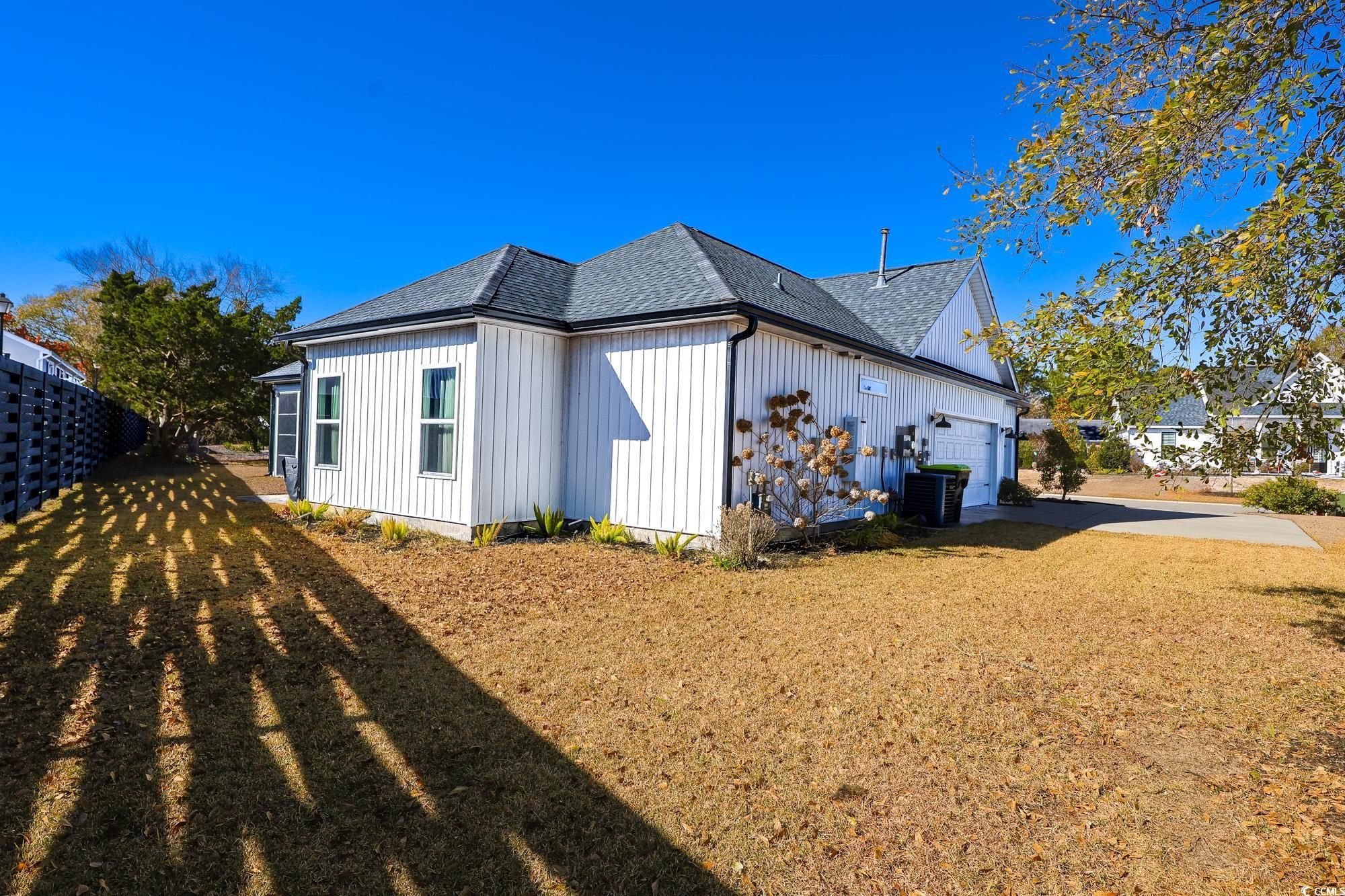 669 Pacific Commons Drive Surfside Beach, SC 29575 - Photo 29 of 36 View of home's exterior featuring a shingled roof, an attached garage, and board and batten siding