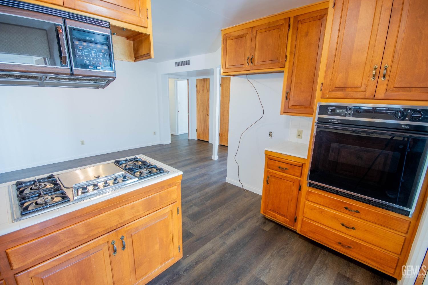 Undisclosed Address Bakersfield, CA 93309 - Photo 15 of 39 a kitchen with granite countertop wooden cabinets and a stove top oven
