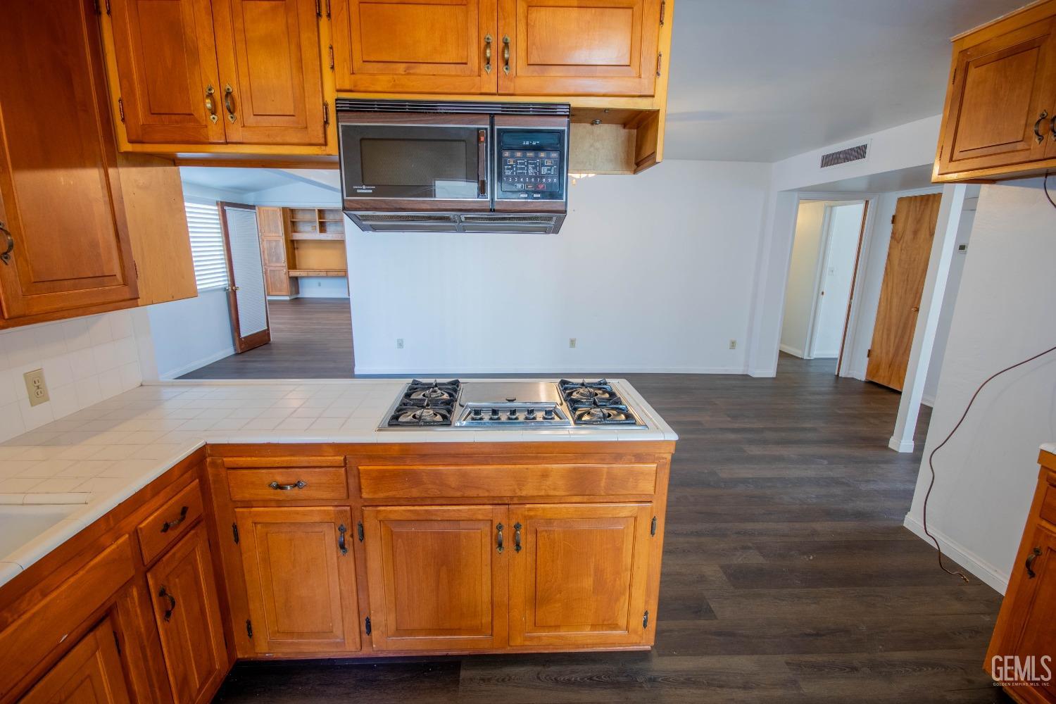 Undisclosed Address Bakersfield, CA 93309 - Photo 16 of 39 a kitchen with granite countertop a stove and a microwave