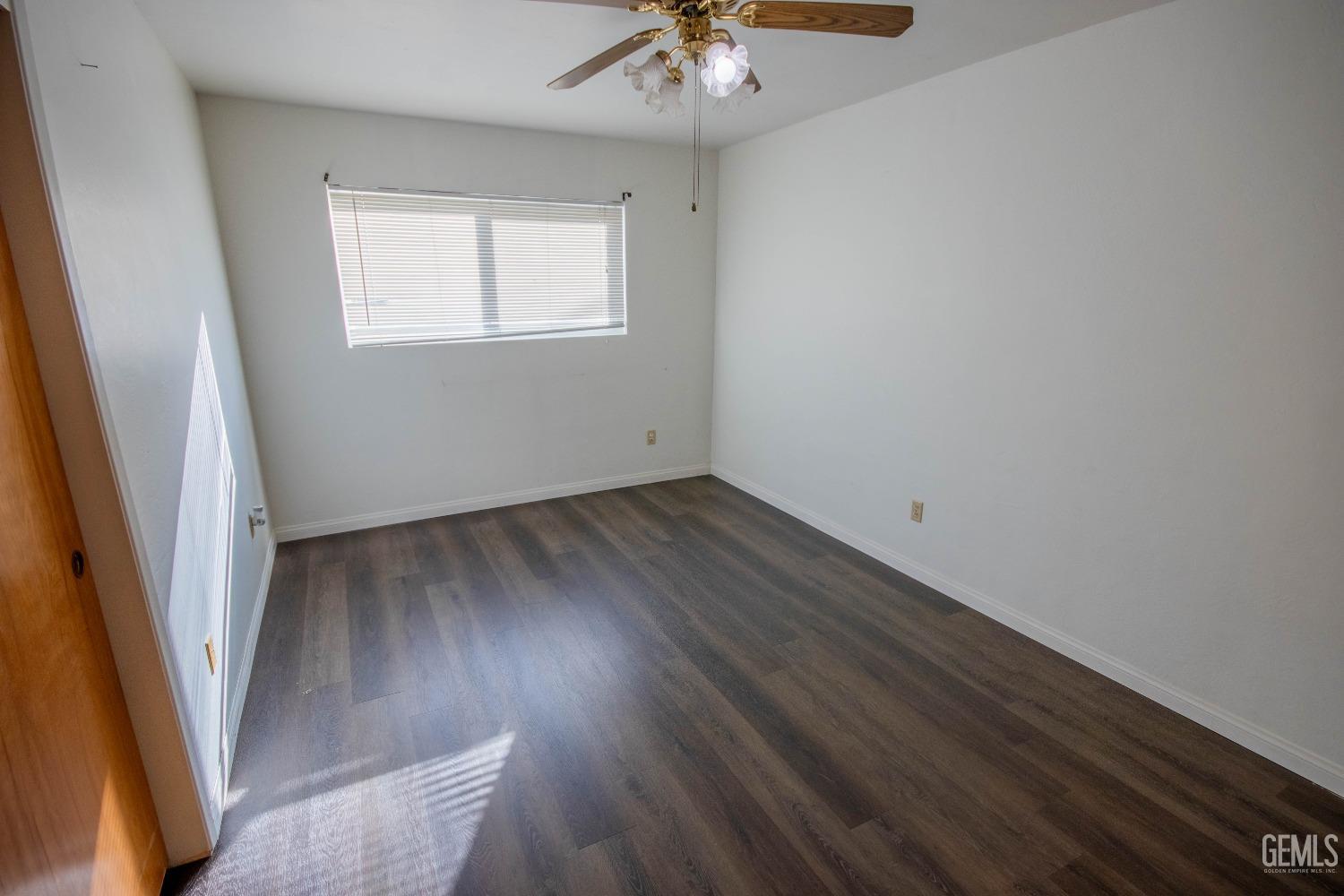 Undisclosed Address Bakersfield, CA 93309 - Photo 25 of 39 an empty room with wooden floor and fan